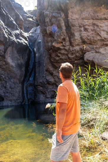A man looking at the waterfall at Charco Azul in El Podemos a Agaete on Gran Canaria, Canary Islands
