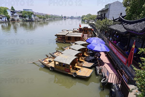 Excursion to Zhujiajiao water village, Shanghai, China, Asia, Wooden boat on canal with view of historical architecture, Traditional boats on a river next to buildings of Chinese architecture, Asia
