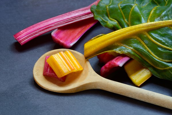 Red and yellow chard, wooden spoon and chopped stems, Beta vulgaris