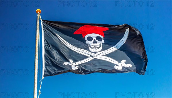 The pirate flag flutters in the wind, isolated against the blue sky