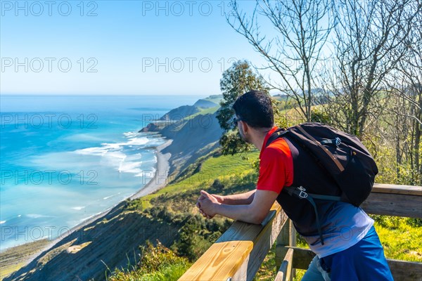 A man looking at the beautiful coastal landscape in the flysch of Zumaia, Gipuzkoa. Basque Country