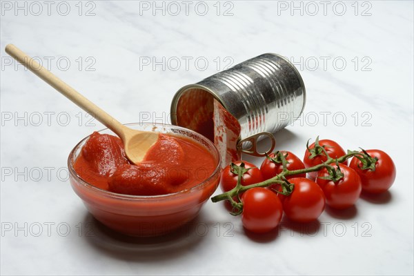 Tinned tomatoes in a bowl, tin can and tomatoes