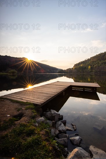 Lake at sunset. Beautiful landscape, taken from the shore of a reservoir. Situated in the middle of the forest and surrounded by nature, the reservoir offers a great atmosphere. Marbach Reservoir, Odenwald, Hesse, Germany, Europe