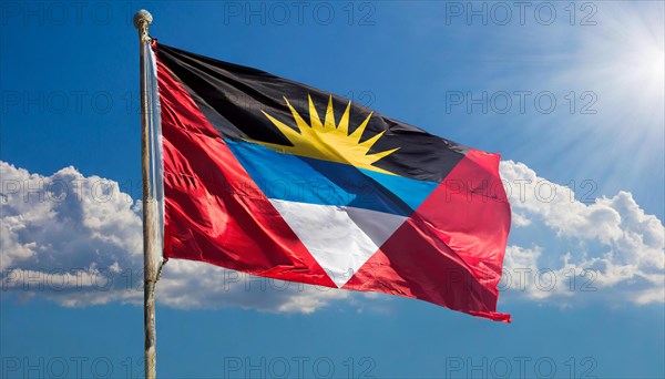 The flag of Antigua flutters in the wind, isolated against the blue sky