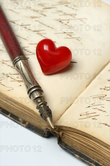 Pen with pen holder and red heart on diary