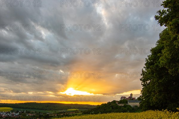 Landscape at sunrise. Beautiful morning landscape with fresh yellow rape fields in spring. Small castle in the yellow fields on a hill. Historic Ronneburg Castle in the middle of nature, Ronneburg, Hesse, Germany, Europe