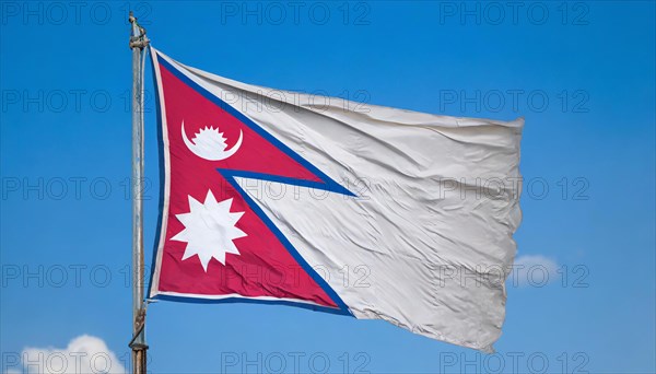 The flag of Nepal, fluttering in the wind, isolated against a blue sky