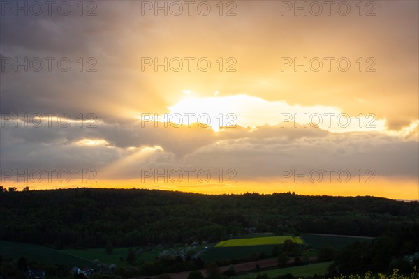 Landscape at sunrise. Beautiful morning landscape with fresh yellow rape fields in spring. Small castle in the yellow fields on a hill. Historic Ronneburg Castle in the middle of nature, Ronneburg, Hesse, Germany, Europe