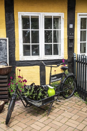 Old bicycle for goods transport at a window in a half-timbered house in Svaneke on the island of Bornholm, Baltic Sea, Denmark, Scandinavia, Northern Europe, Europe