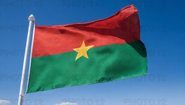 The flag of Burkina Faso flutters in the wind, isolated against the blue sky