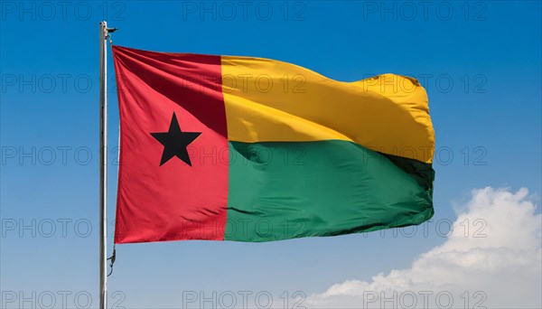 The flag of Guinea-Bissau, fluttering in the wind, isolated, against the blue sky