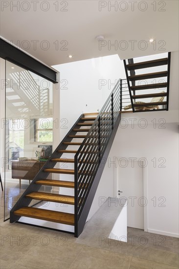 American walnut wood and black powder coated cold rolled steel stairs inside modern cube style home, Quebec, Canada, North America