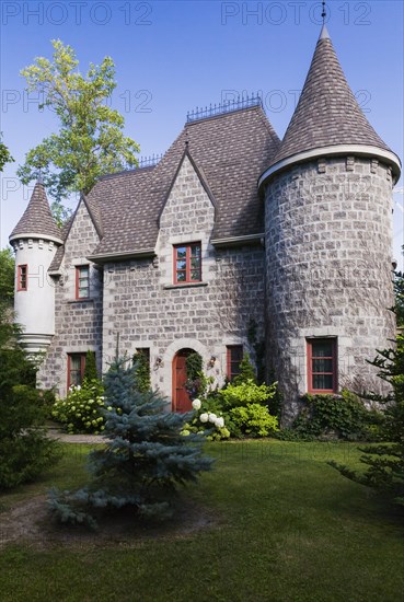 2006 reproduction of a 16th century grey stone and mortar Renaissance castle style residential home facade in summer, Quebec, Canada, North America