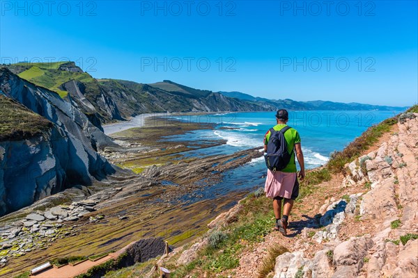 A man in Algorri cove on the coast in the Zumaia flysch without people, Gipuzkoa. Basque Country