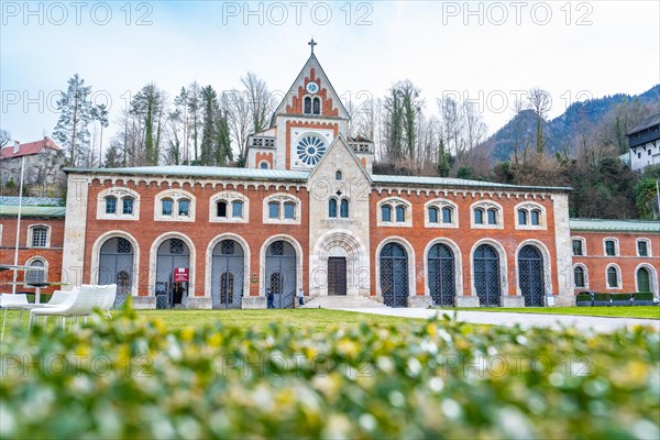 Old salt worksWide-angle shot of a Gothic church with brick facade in front of a hilly landscape, Bad Reichenhall, Bavaria, Germany, Europe