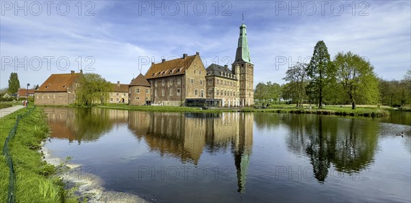 View over wide moat to historic moated castle from Renaissance Raesfeld Castle reflected in moat in spring, Freiheit Raesfeld, Muensterland, North Rhine-Westphalia, Germany, Europe