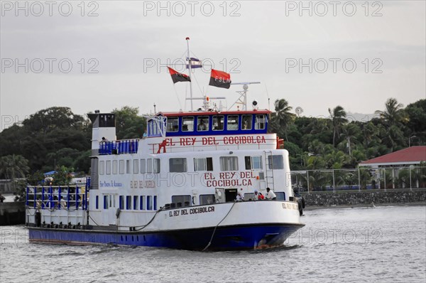 Lake Nicaragua, Ometepe Island in the background, Illuminated ferry at the dock at dusk with a clear sky and the sign 'EL REY DEL COCIBOLCA', Nicaragua, Central America, Central America