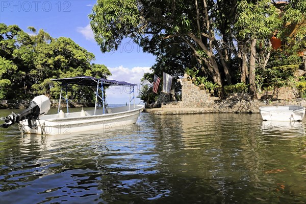 Granada, Nicaragua, A motorboat on a calm water next to tropical trees, Central America, Central America