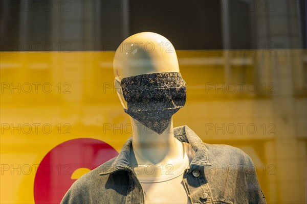 Mannequin with a corona mask on its face in a shop window of a fashion shop in the city centre of Weimar, Thuringia, Germany, Europe