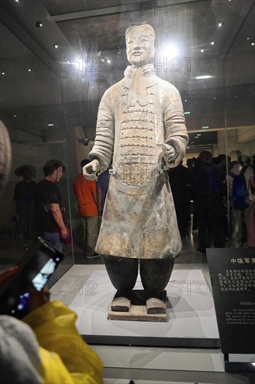 Figures of the terracotta army, Xian, Shaanxi Province, China, Asia, Terracotta warrior standing in a museum display case, surrounded by museum visitors, Xian, Shaanxi Province, China, Asia