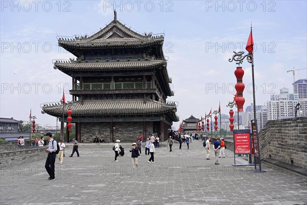 Xian, Shaanxi Province, China, People walk past an old decorative tower under a clear sky, Xian, Shaanxi Province, China, Asia