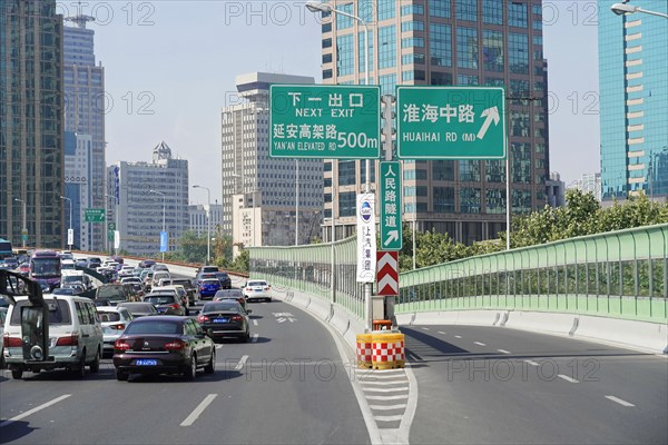 Traffic in Shanghai, Shanghai Shi, People's Republic of China, city motorway with direction signs, surrounded by skyscrapers and clear sky, Shanghai, China, Asia