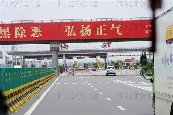 Xian, Shaanxi, China, Asia, Urban road with red banner and Chinese characters above the carriageway, Asia