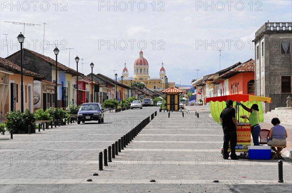 Granada, Nicaragua, View of a busy street running towards a yellow domed cathedral, Central America, Central America
