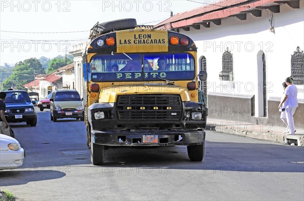 Leon, Nicaragua, A colourfully painted bus stands in the flow of traffic on a road, Central America, Central America