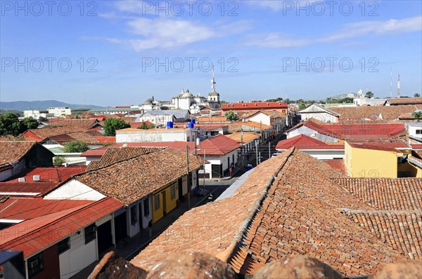 Leon, Nicaragua, View over the red tiled roofs of a town with church towers in the background under a clear sky, Central America, Central America