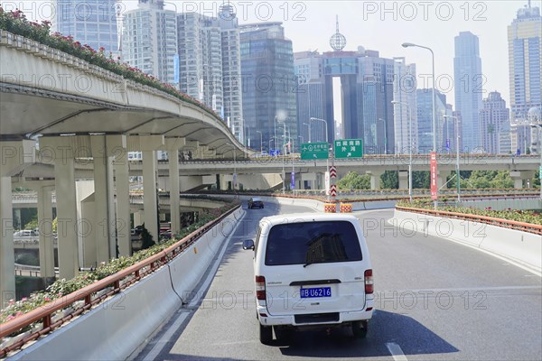 Traffic in Shanghai, Shanghai Shi, People's Republic of China, Single-lane traffic on an urban motorway with bridges and tall buildings, Shanghai, China, Asia