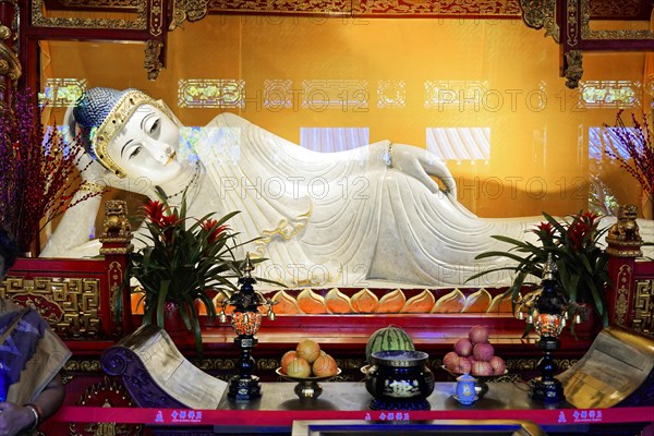 Reclining Jade Buddha, Jade Buddha Temple, Shanghai, Buddha at the altar surrounded by offerings and floral decorations in a peaceful mood, Shanghai, China, Asia