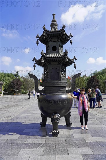 Chongqing, Chongqing Province, China, Asia, Large traditional Chinese incense burner on a square with a person next to it, Asia