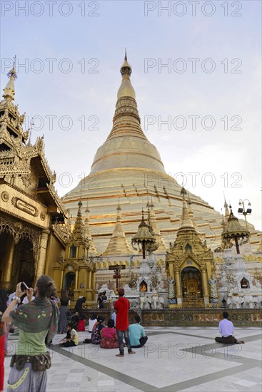 Shwedagon Pagoda, Yangon, Myanmar, Asia, Visitors in front of the golden Shwedagon Pagoda with clear blue sky in the background, Asia