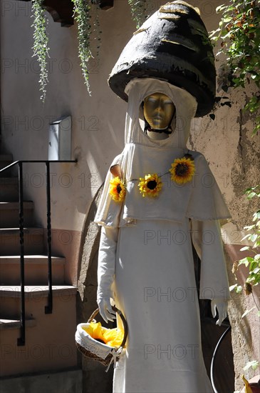 Eguisheim, Alsace, France, Europe, A statue of a woman in a white robe, decorated with sunflowers, Europe