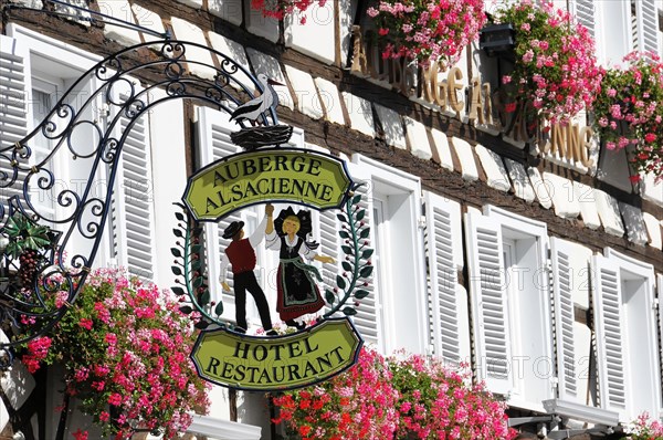 Eguisheim, Alsace, France, Europe, Hotel and restaurant sign 'Auberge Alsacienne' with floral decoration, Europe