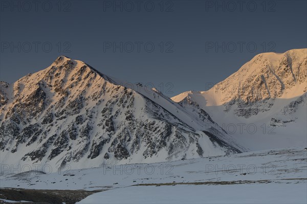 Sunrise over the mountain peaks in the snowy Tavan Bogd National Park, Mongolian Altai Mountains, Western Mongolia, Mongolia, Asia