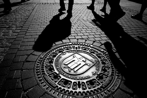 Muenchner Kindl on a manhole cover in the pedestrian zone, Munich, Bavaria, Germany, Europe