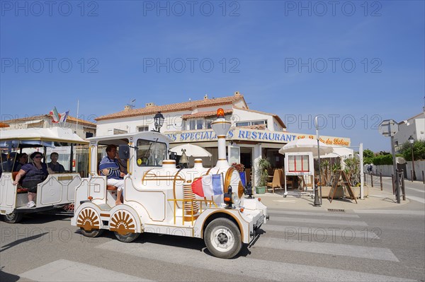 Railway or slow train in front of a restaurant, Les Saintes-Maries-de-la-Mer, Camargue, Bouches-du-Rhone, Provence-Alpes-Cote d'Azur, South of France, France, Europe