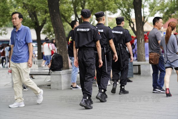 China, Beijing, Forbidden City, UNESCO World Heritage Site, A group of security guards patrols on foot through an urban neighbourhood, Asia