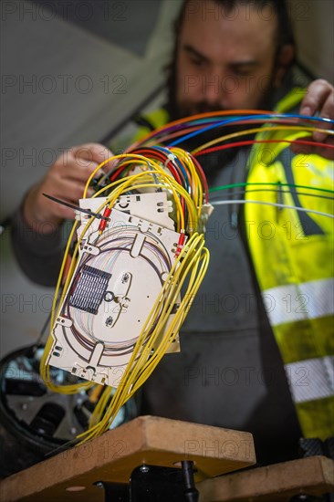 Electrician works concentrated on the wiring of technical devices, Galsfaserbau, Calw, Black Forest, Germany, Europe