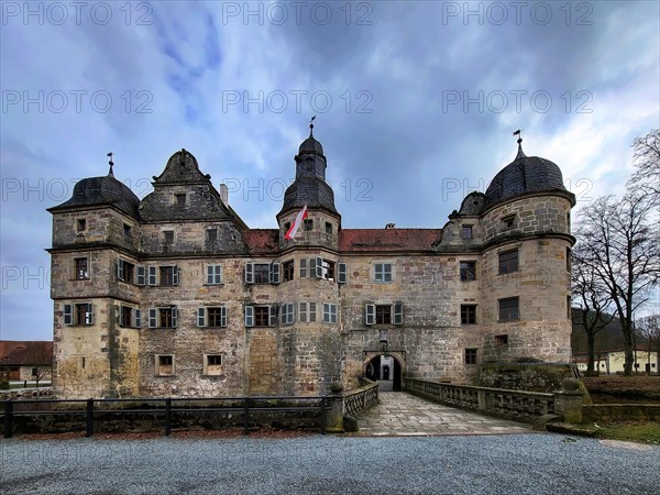 Mitwitz moated castle under a cloudy sky. Mitwitz, Kronach, Upper Franconia, Bavaria, Germany, Europe