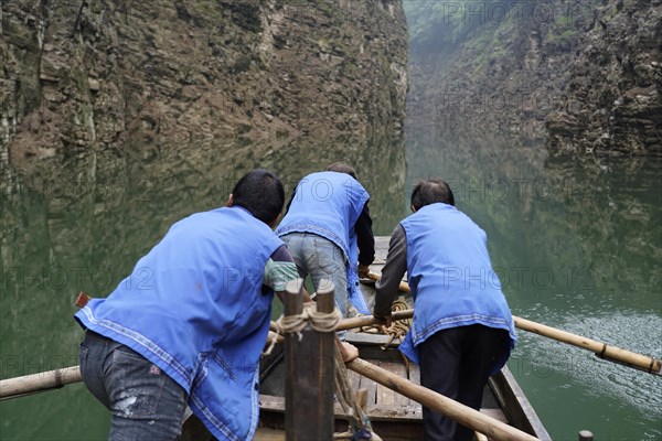 Special boats for the side arms of the Yangtze, for river cruise ship tourists, Yichang, China, Asia, Workers show teamwork by manoeuvring a wooden boat on a river in a gorge, Hubei province, Asia