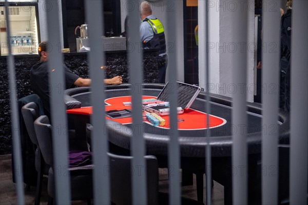 Interior view of a casino with a view of a poker table and the surveillance personnel, The Cologne police led a raid against illegal gambling on Friday evening. Around 200 investigators from the police, customs, tax investigation, the public order office, the tax and revenue office, the immigration office and the public catering office were out on the streets of Cologne on Friday evening. They search 25 properties where there are indications that illegal gambling is taking place. And they make a find