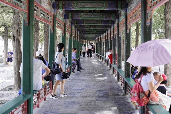New Summer Palace, Beijing, China, Asia, A group of people walk under a traditionally decorated long corridor, Beijing, Asia