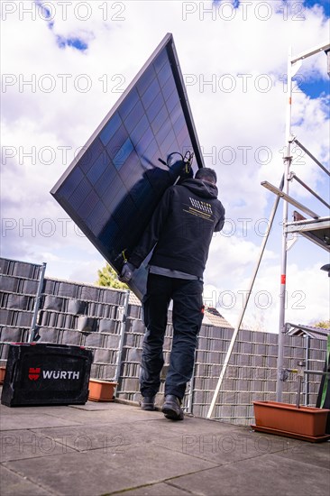 A craftsman installs a solar panel on a roof, solar systems construction, crafts, Muehlacker, Enzkreis, Germany, Europe