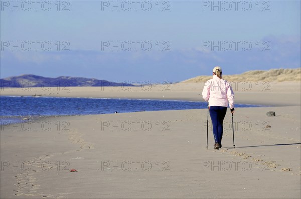 Sylt, Schleswig-Holstein, A person Nordic walking on the beach with a view of the sea, Sylt, North Frisian Island, Schleswig-Holstein, Germany, Europe