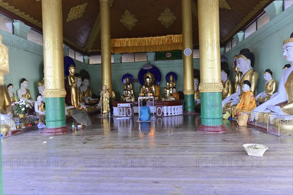 Shwedagon Pagoda, Yangon, Myanmar, Asia, Interior of a temple with Buddha statues and worshippers, Asia