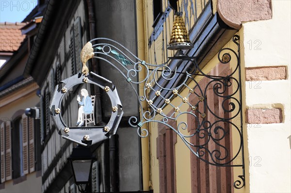 Kaysersberg, Alsace Wine Route, Alsace, Departement Haut-Rhin, France, Europe, An artistically forged bracket with a restaurant symbol hangs from a building, Europe