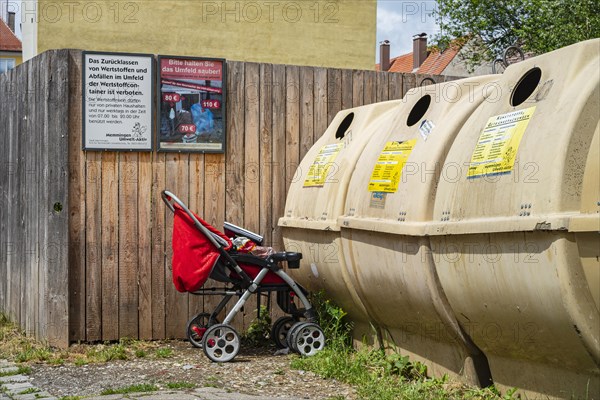 Pushchair left in front of a recycling container in the old town centre of Memmingen, Swabia, Bavaria, Germany, Europe